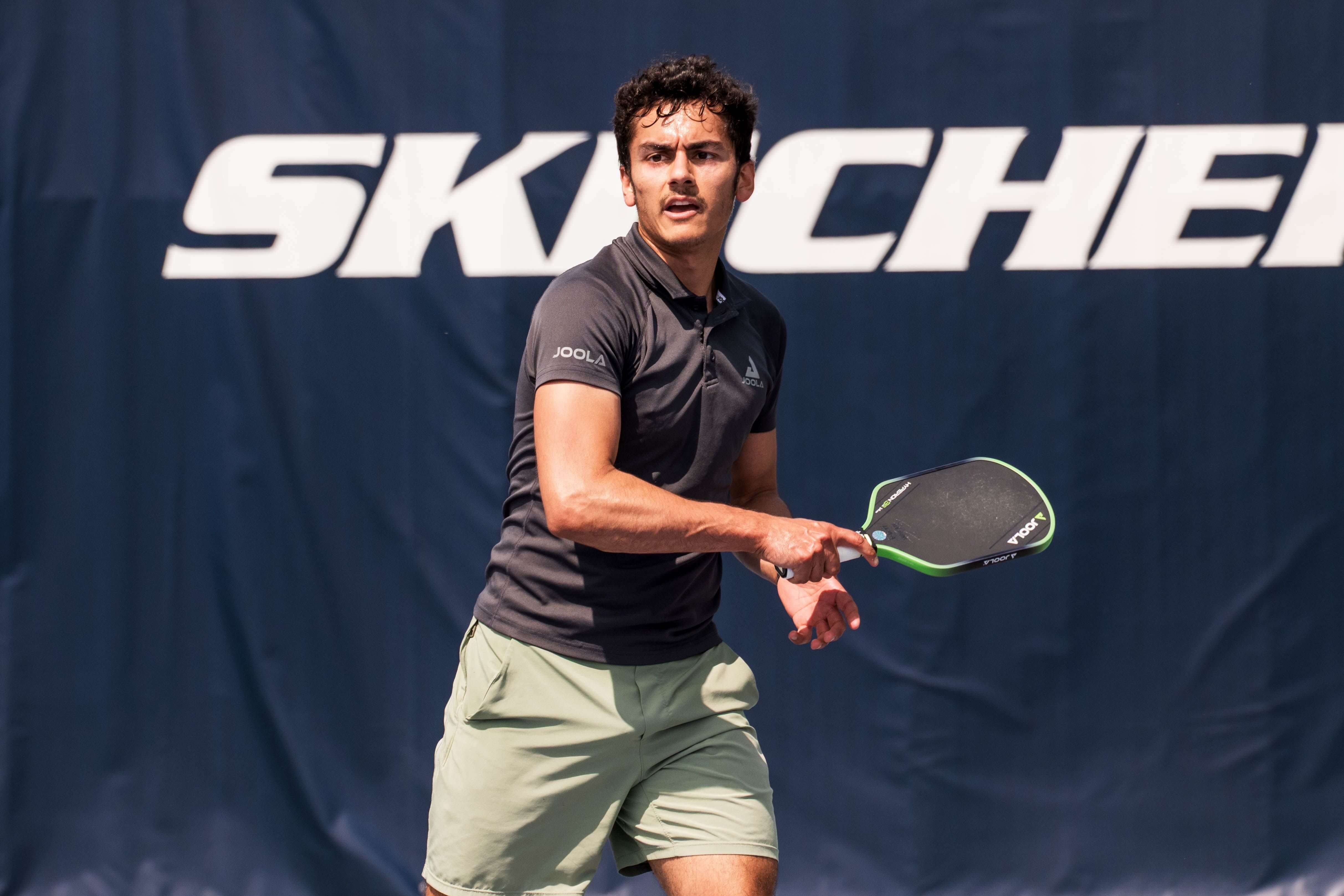 Annik Lohani in light green shorts and black polo