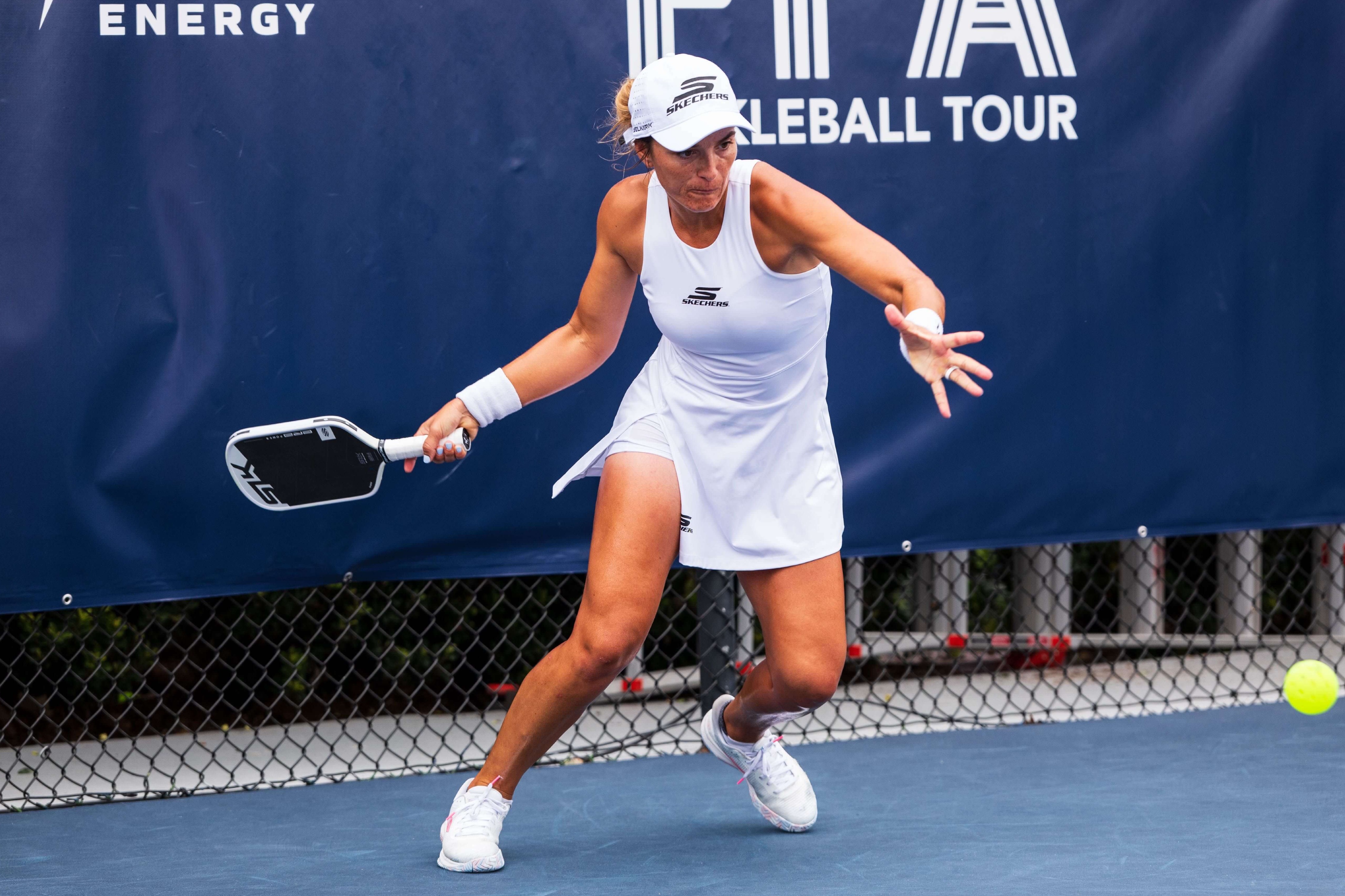 Catherine Parenteau in a white tennis dress with a high slit
