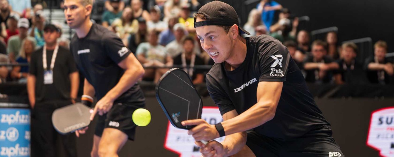 Connor Garnett hitting a two hadned backhand during a match.