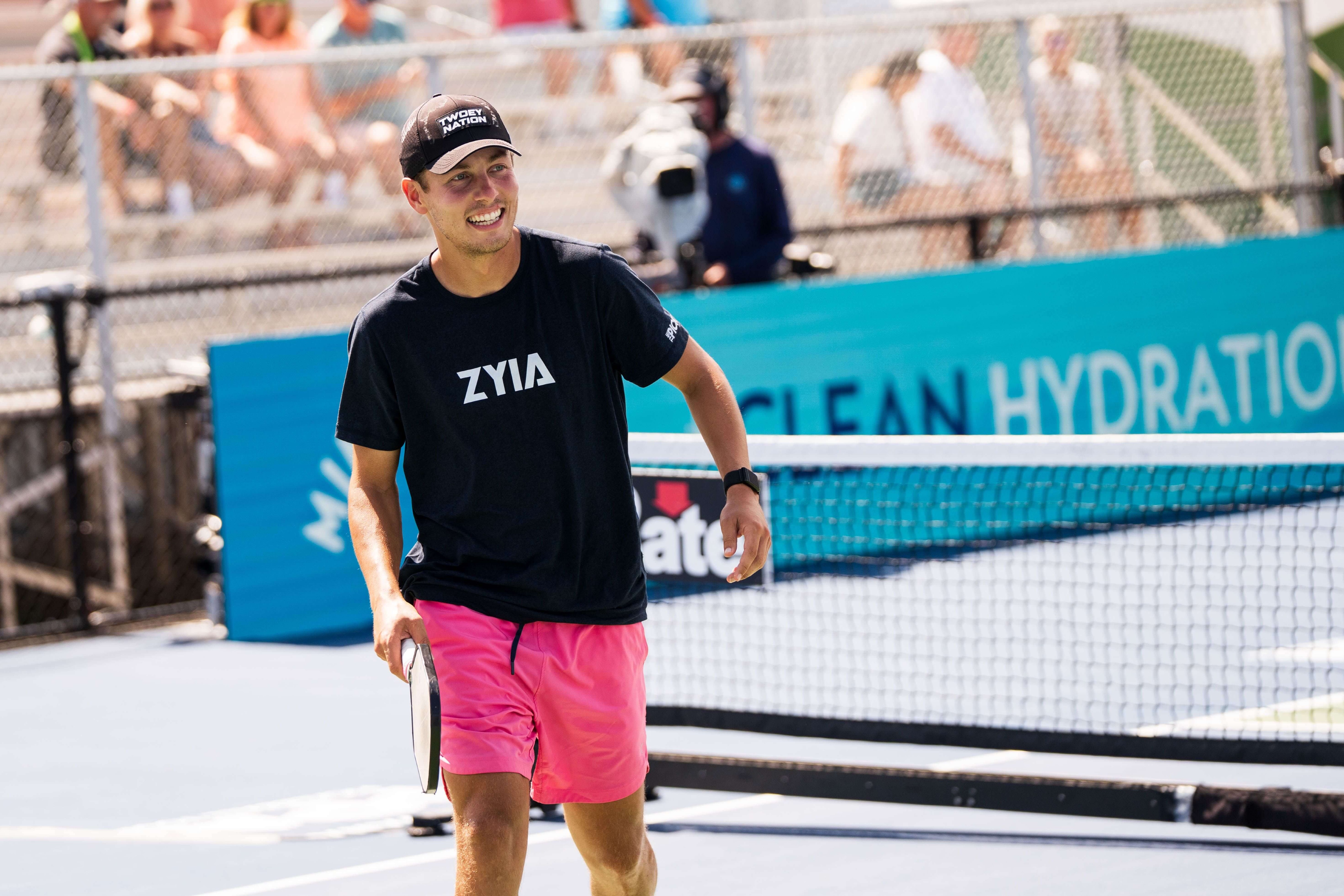 Garnett in a black t-shirt and hot pink shorts
