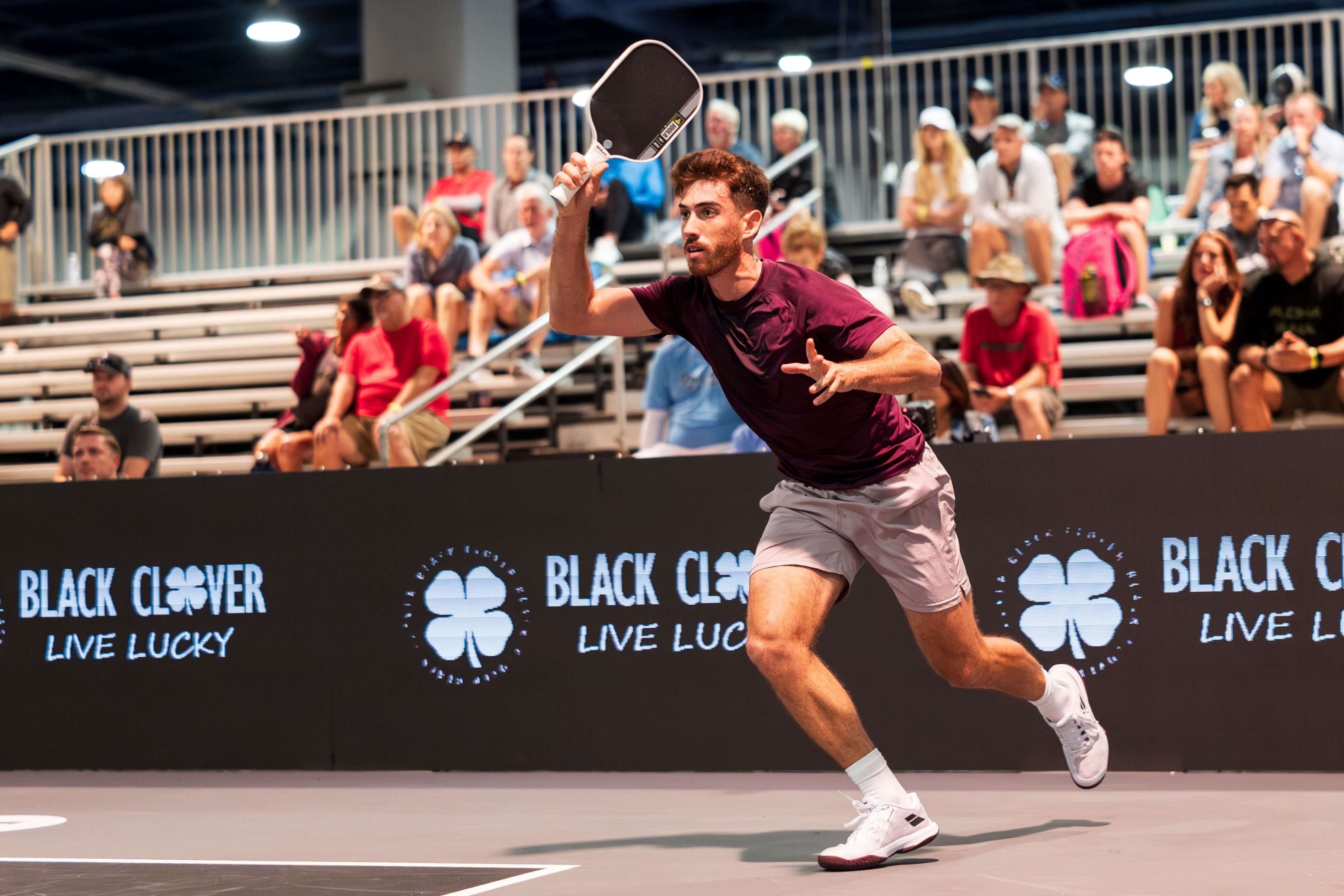 Staksrud in a dark purple shirt, light purple shorts, and white shoes