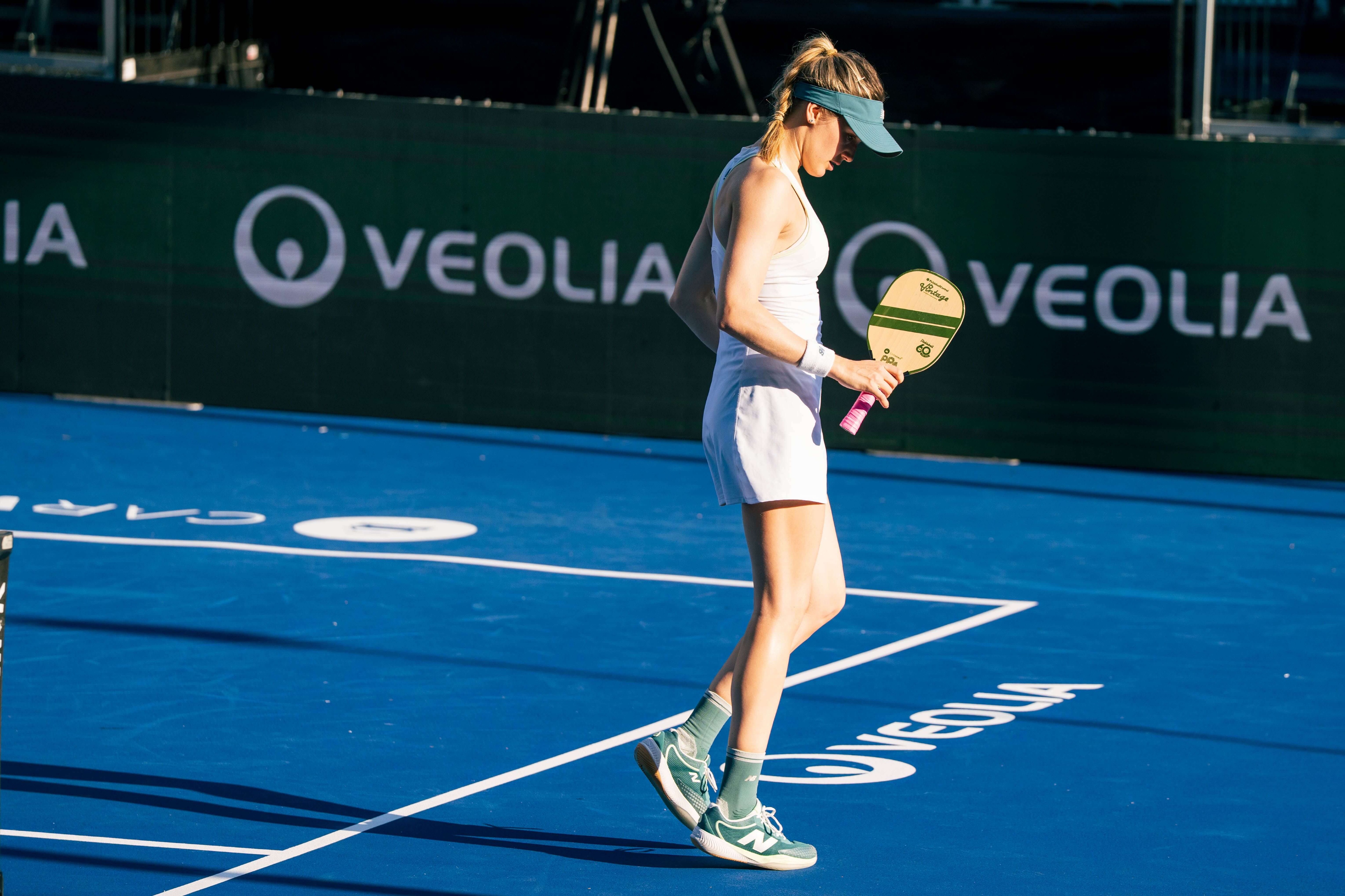 Bouchard in a white dress and dark green shoes