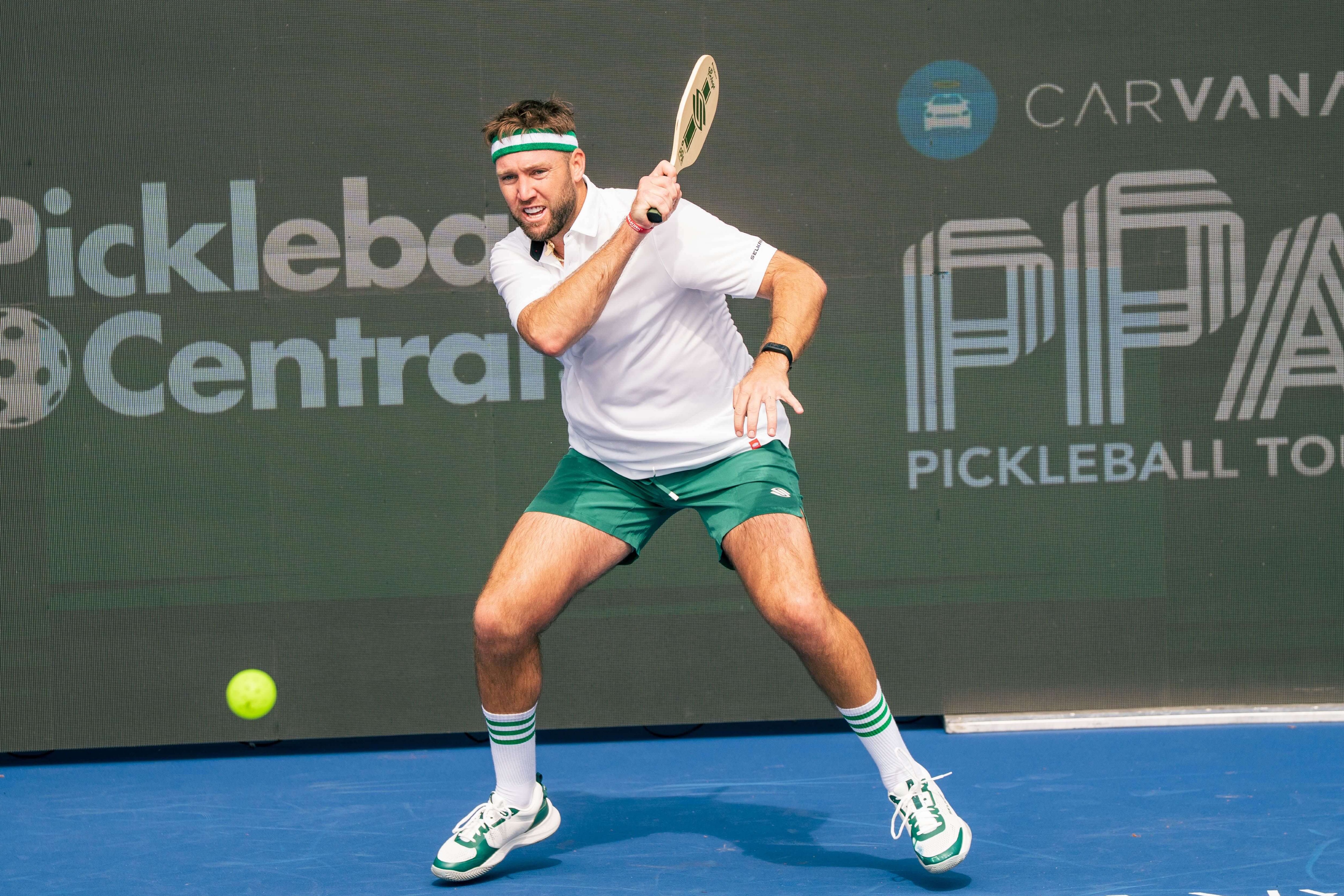 Sock in a white collared shirt, green shorts, green and white acessories