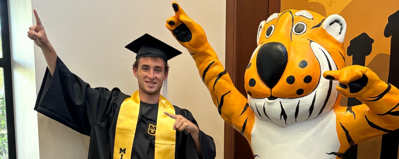 Dylan Frazier posing with Truman the Tiger, the official mascot of the University of Missouri. 