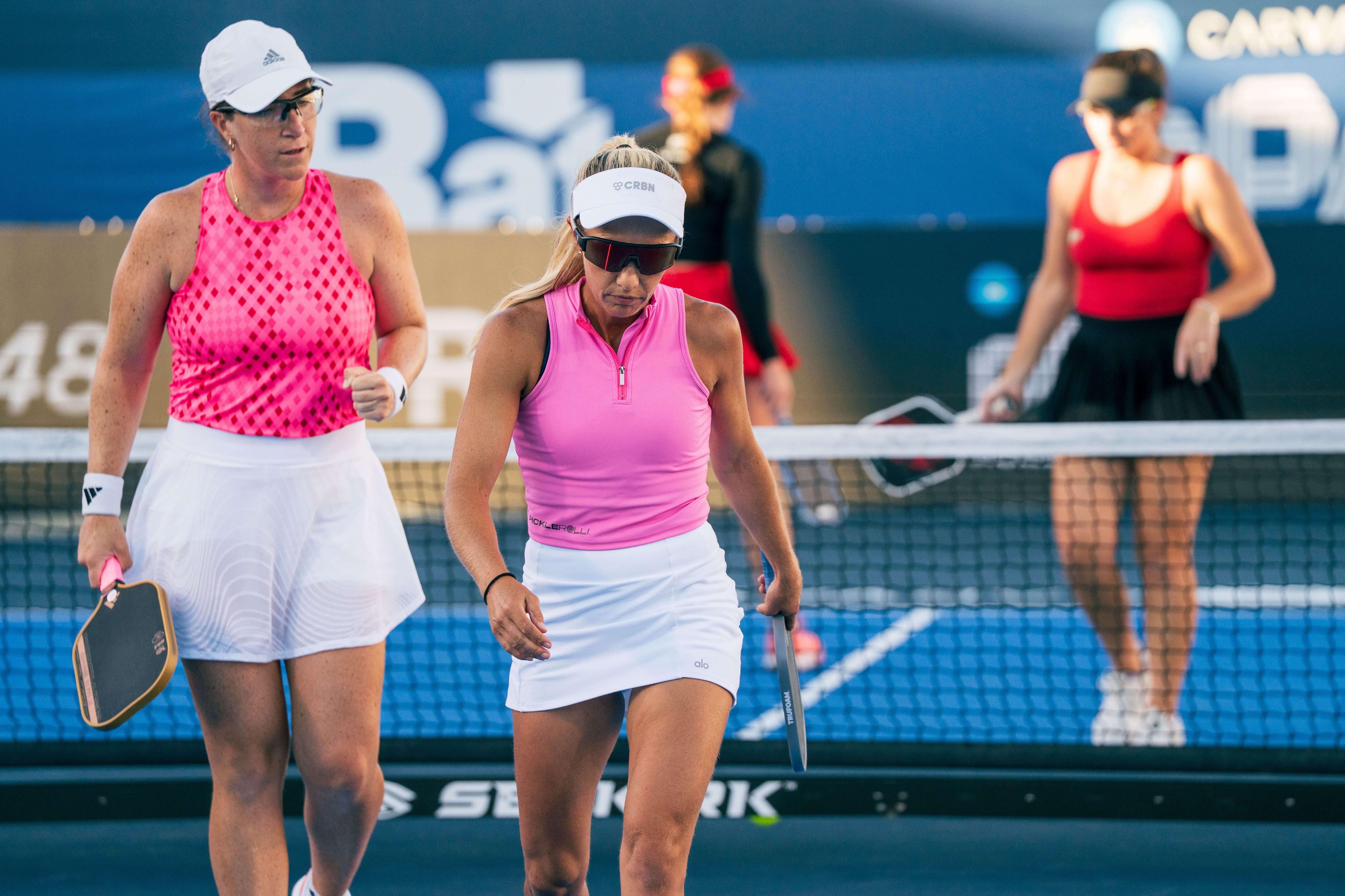 Mari and Allyce in pink tops and white skirts