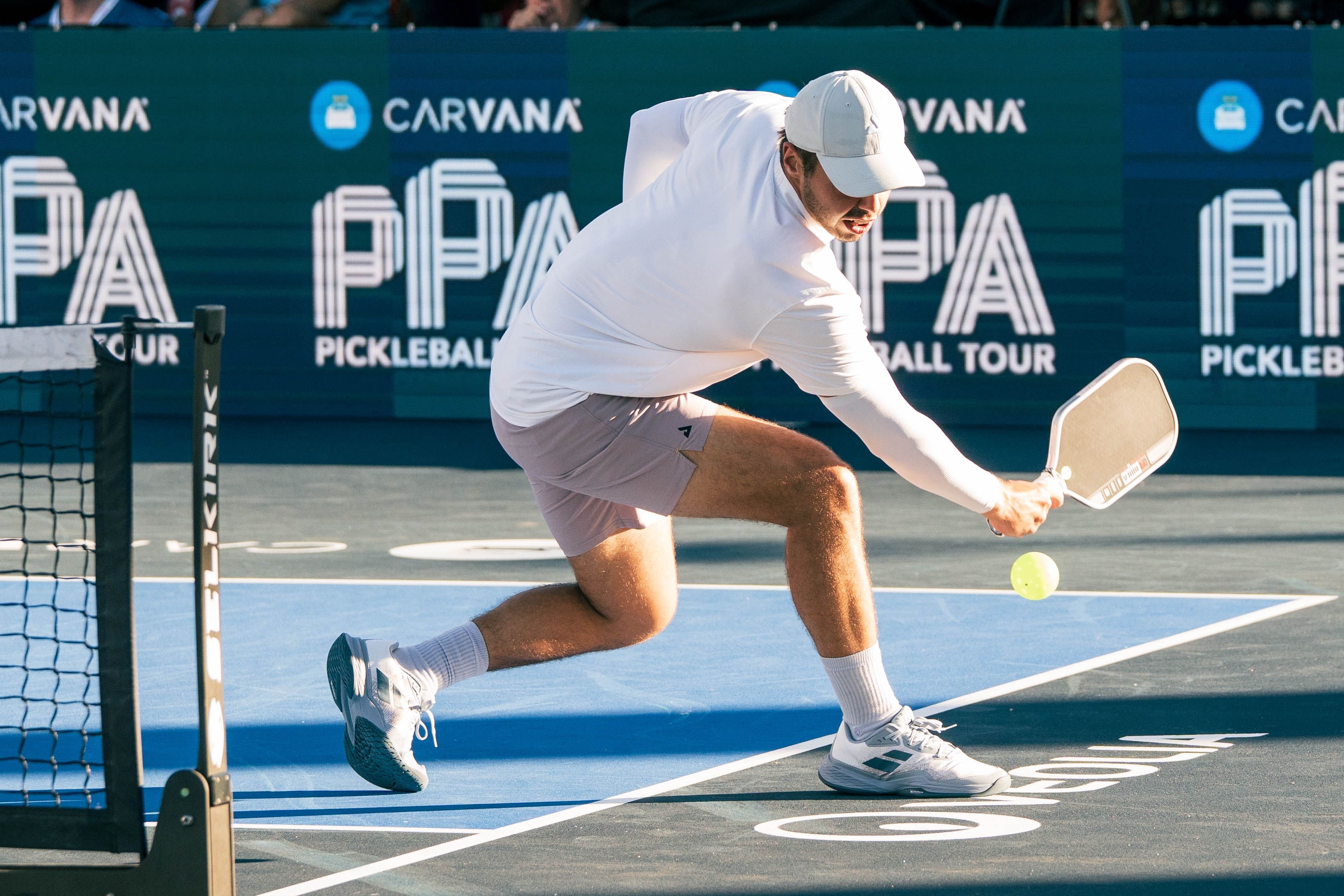 Johns in a white shirt, light pink shorts, and white shoes