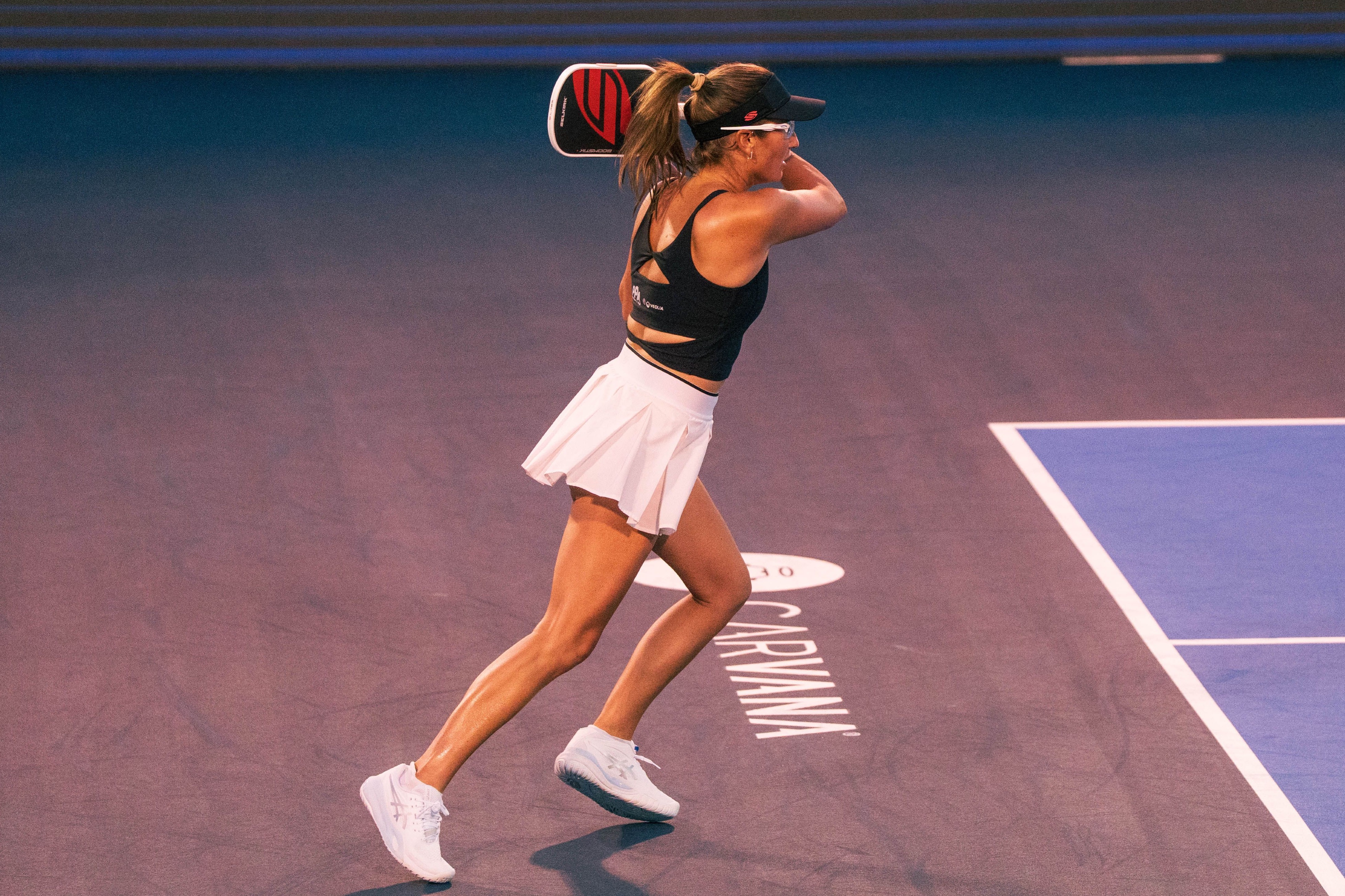 Stratman in a black top and white skirt