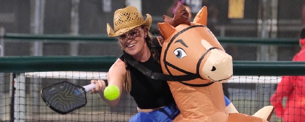 Mary Brascia playing inflatable pickleball while dressed as a cowboy.