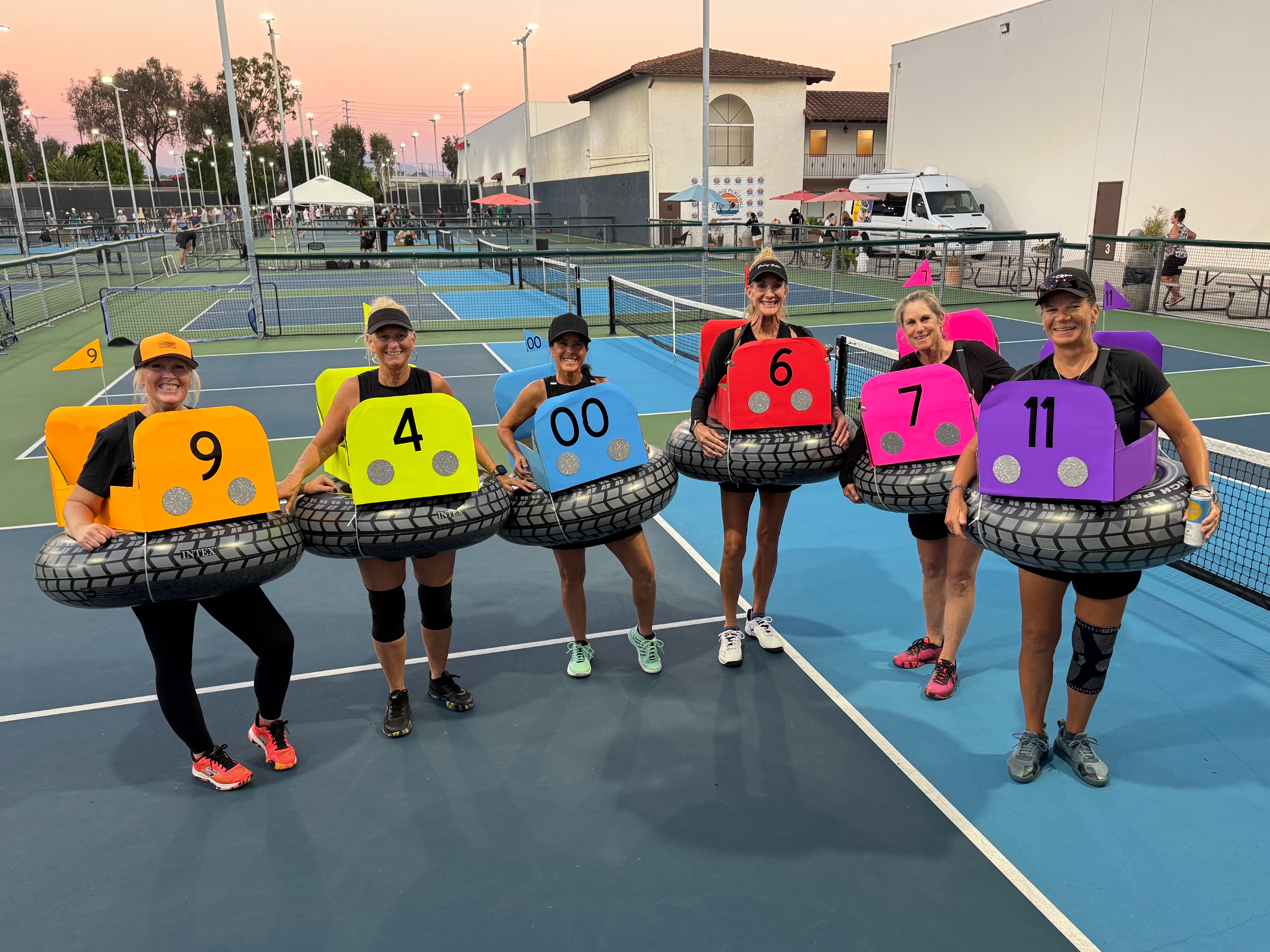 Group of women dressed up as bumper cars on the pickleball court