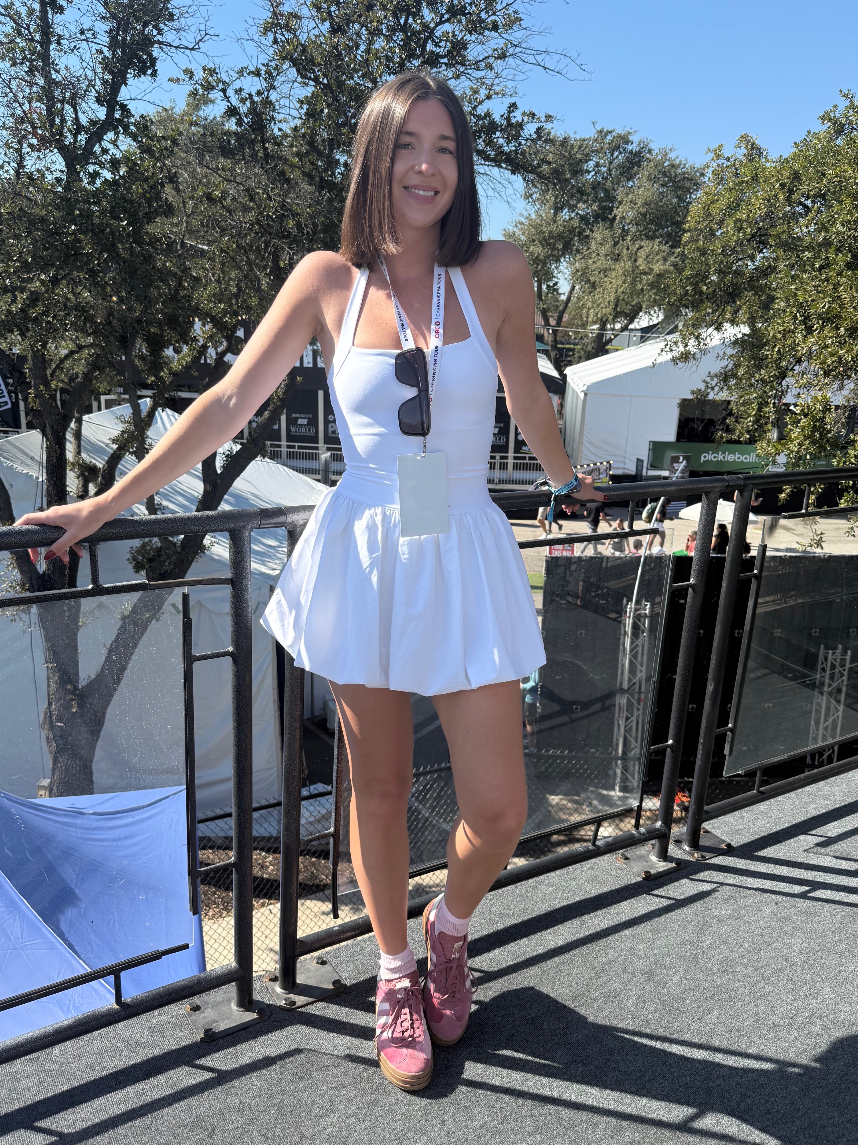 Eva Moore in a white dress and pink tennis shoes