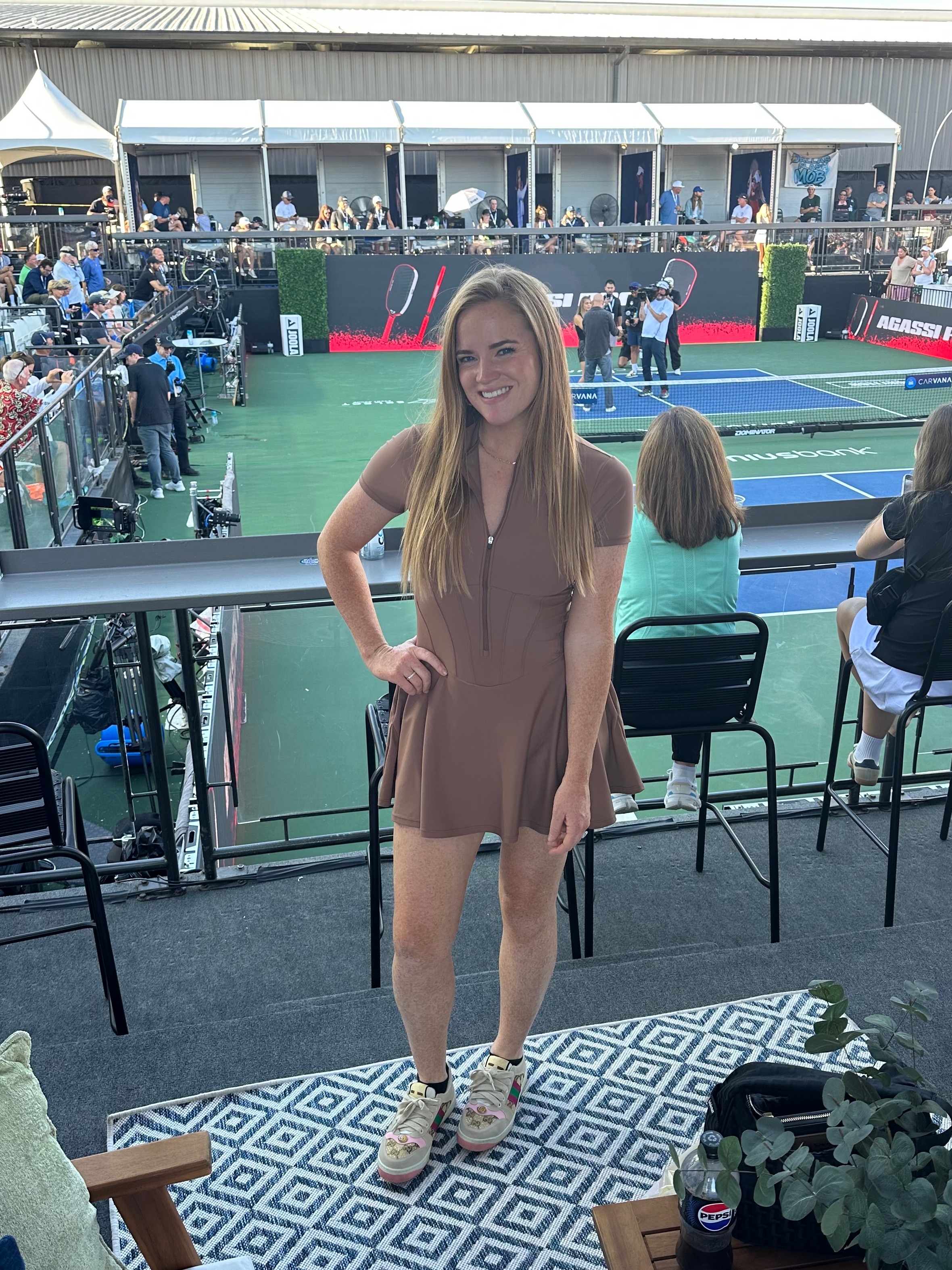 McMahon in a fitted brown dress and Gucci shoes