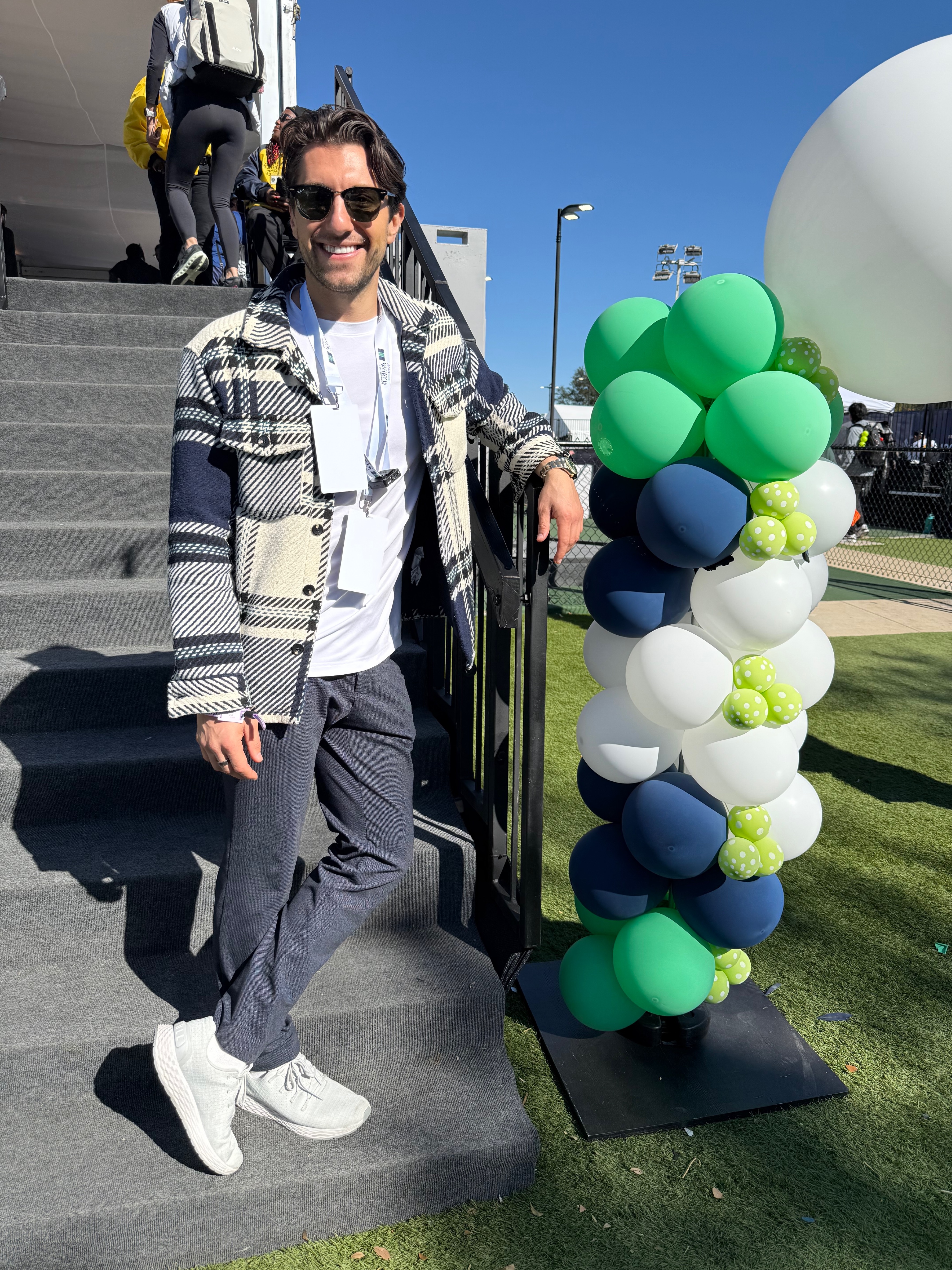 Tartick in a plaid jacket, gray pants, and white shoes