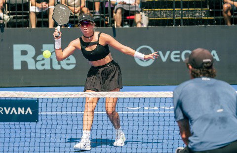 Anna Leigh Waters wearing a black top with a knot in it and a matching skirt.